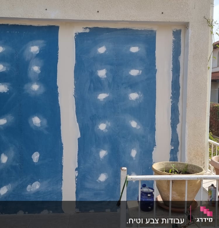 קיר צבוע בכחול עם כתמים לבנים